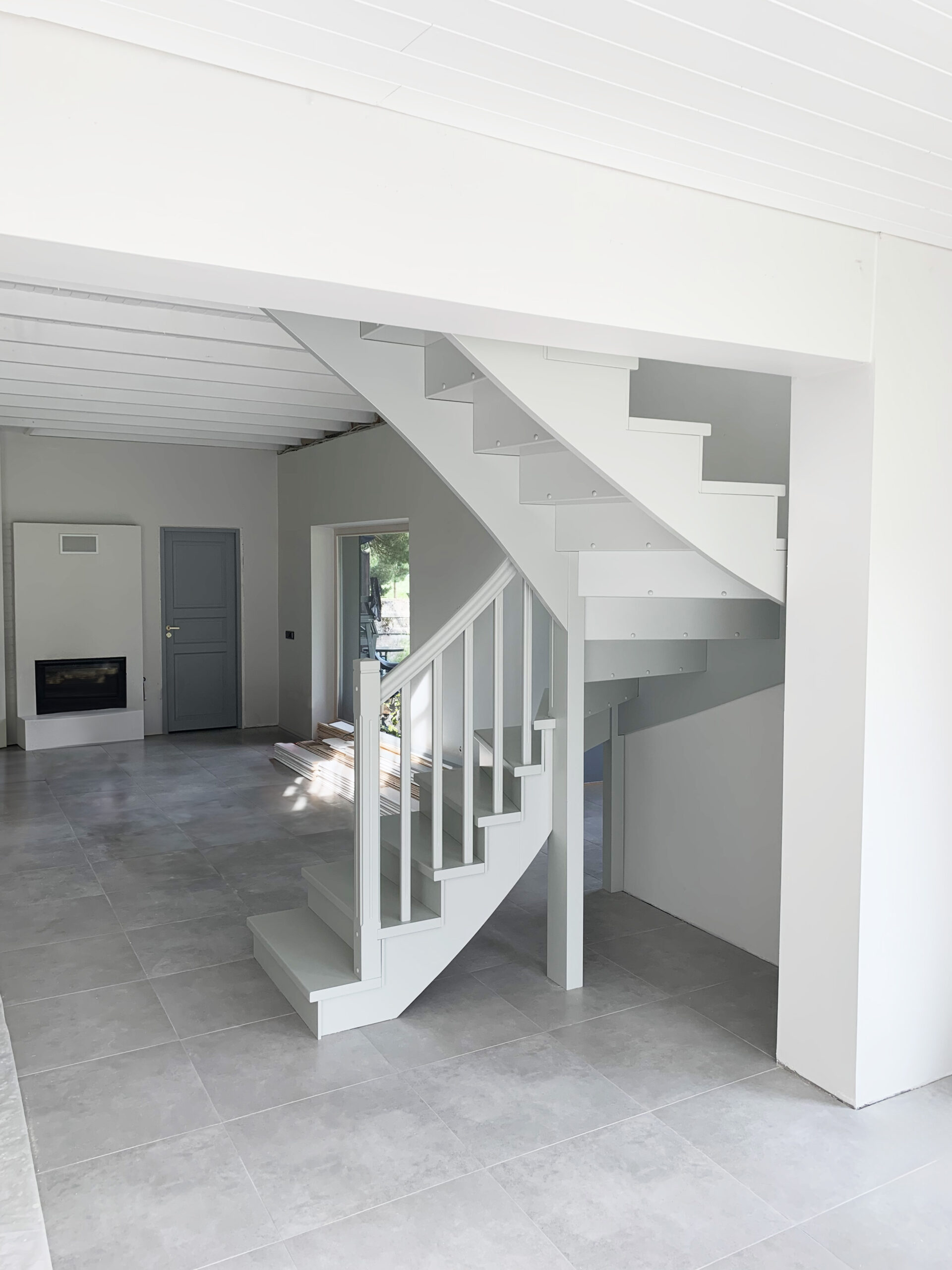 White light wood corner staircase with handrail.