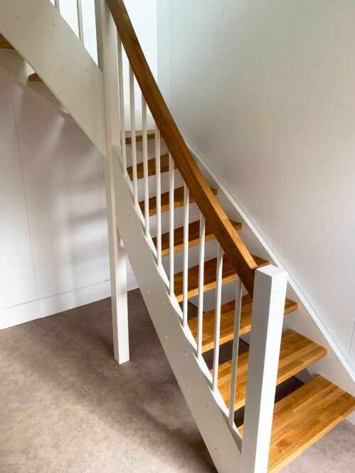 L-shaped staircase with oak steps with a light finish.