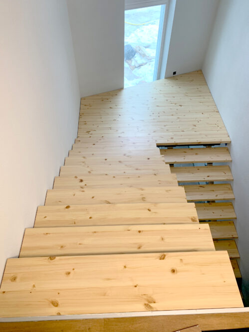 U-shaped pine staircase with a central beam. Light finish