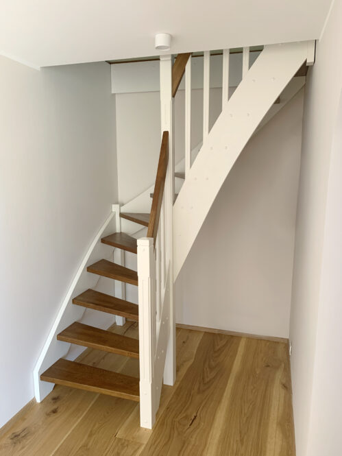 Oak wood L-shaped staircase. Light-dark finish.