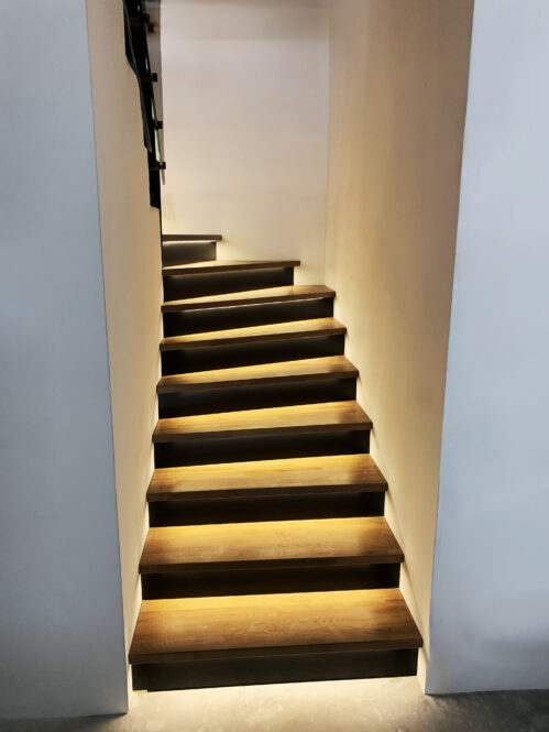 U-shaped staircase with glass railing. Additional LED light strips. 