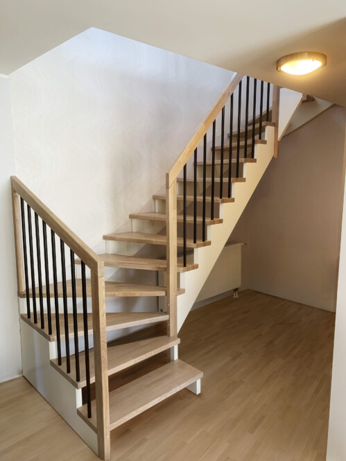 L-shaped staircase with modern stringer. Light-dark finish.