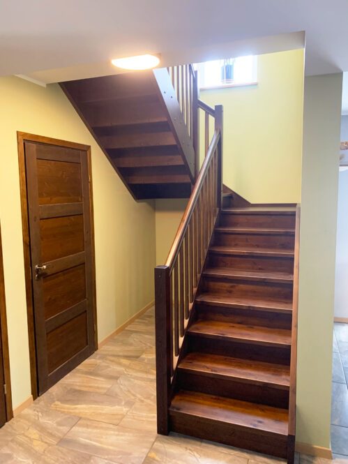 U-shaped staircase with dark finish pine steps.