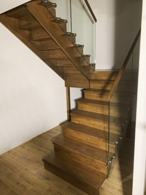 U-shaped staircase with glass railing, oak steps.