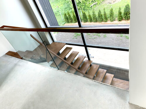 U-shaped staircase with central beam. Materials wood and glass.