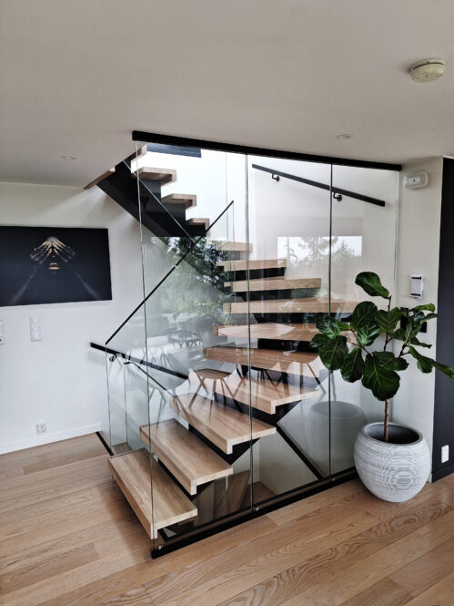 U-shaped staircase with a central beam and glass railing.