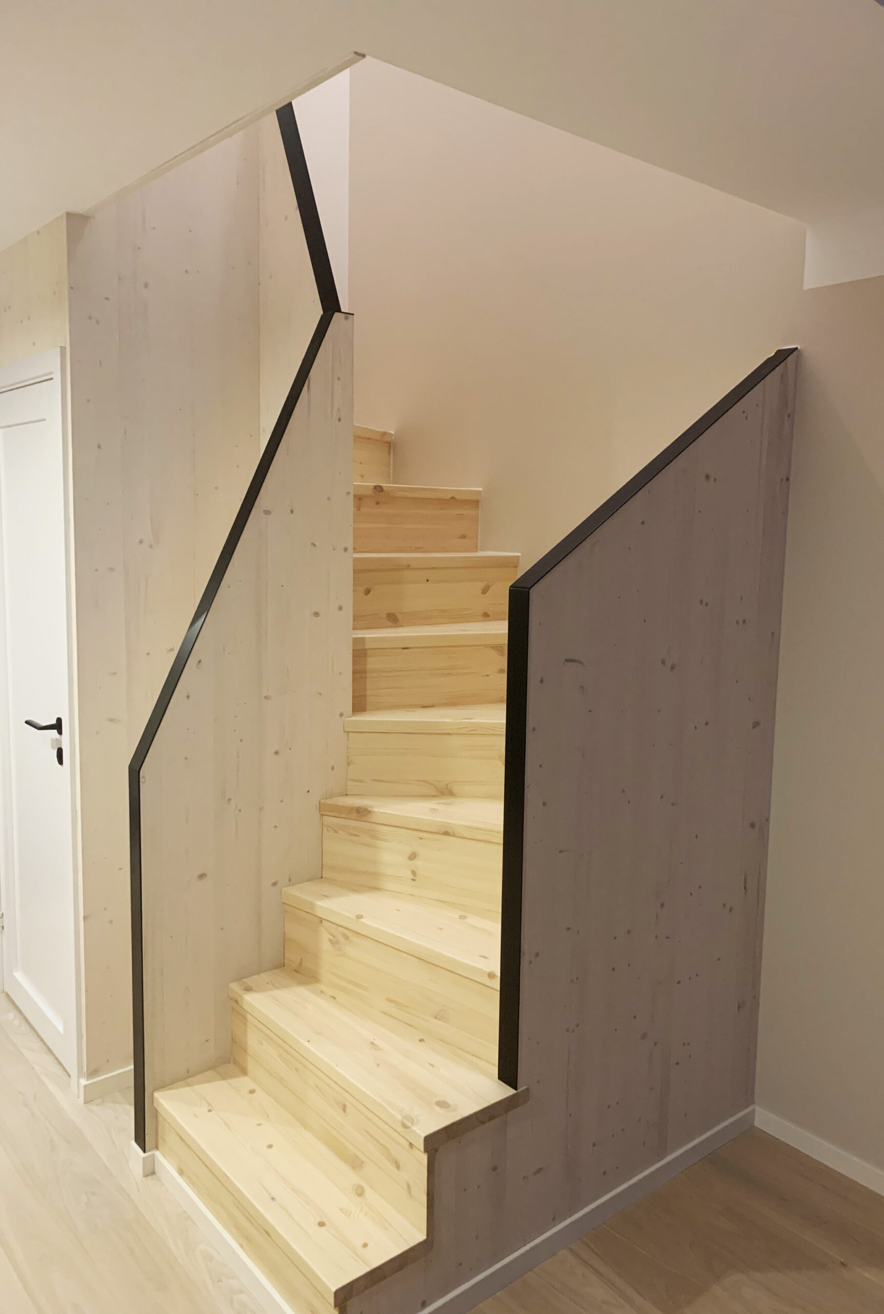 U-shaped staircase with light finish pine steps.