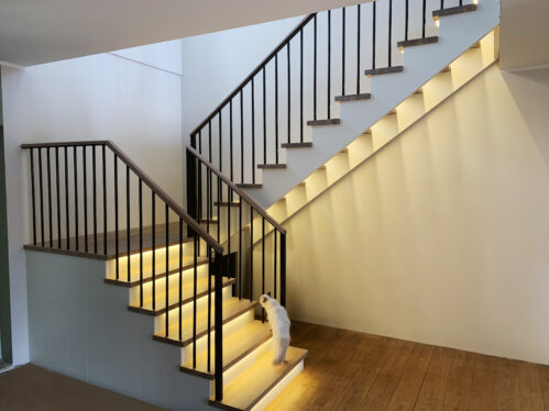 U-shaped staircase with LED lighting. Metal railing posts.