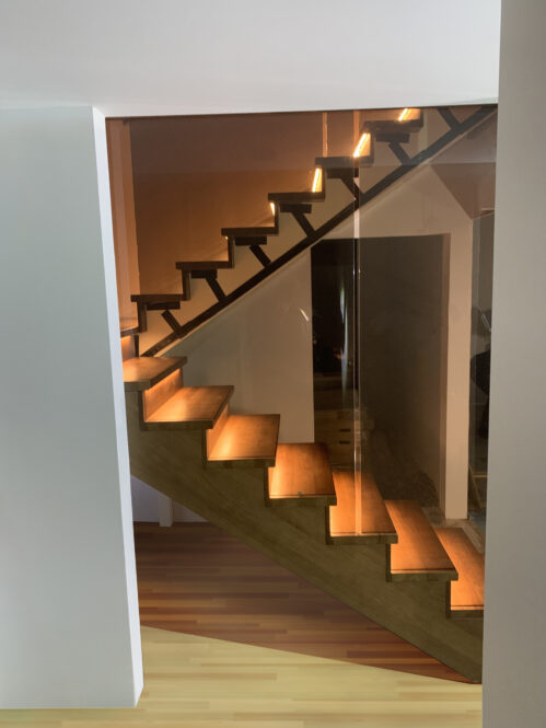 U-shaped staircase with modern stringer and LED lighting.