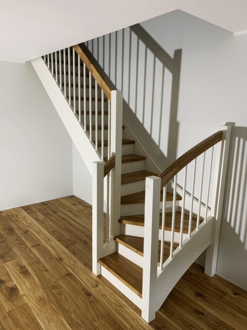 L-shaped staircase with oak steps. With a light finish.