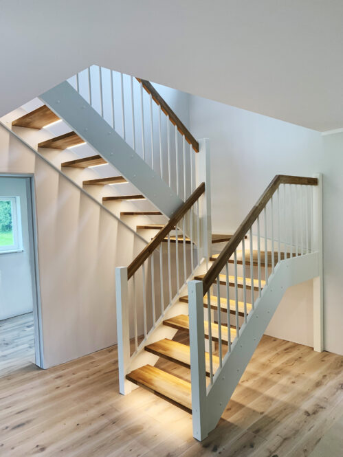 U-shaped staircase with oak steps with LED lighting.