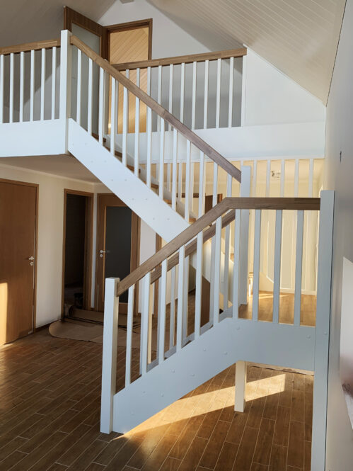 U-shaped staircase with classic stringers and oak steps.