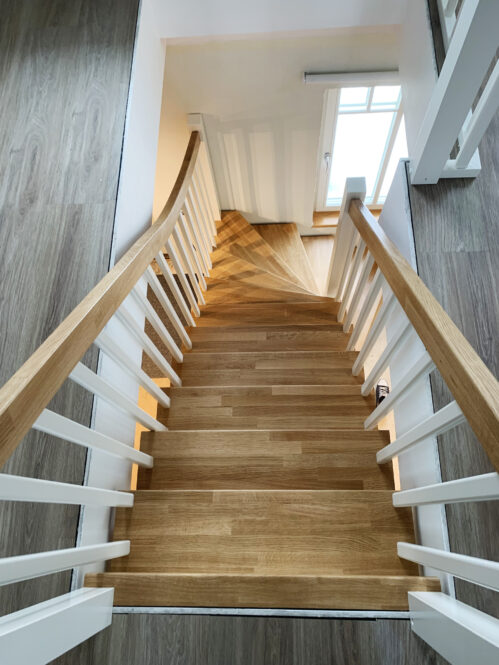 L-shaped staircase with modern stringers and oak steps.