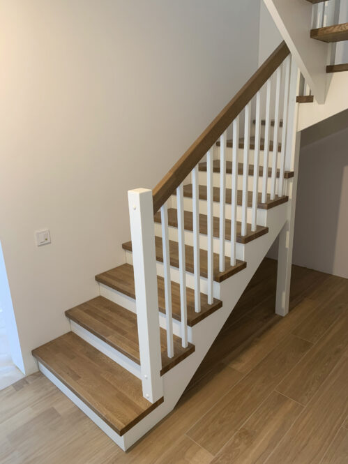 U-shaped staircase with oak steps and modern stringers.