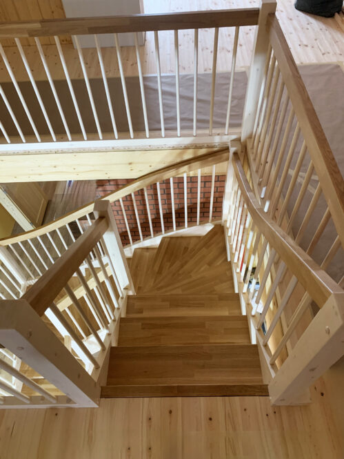 U-shaped staircase with classic stringers and oak steps.