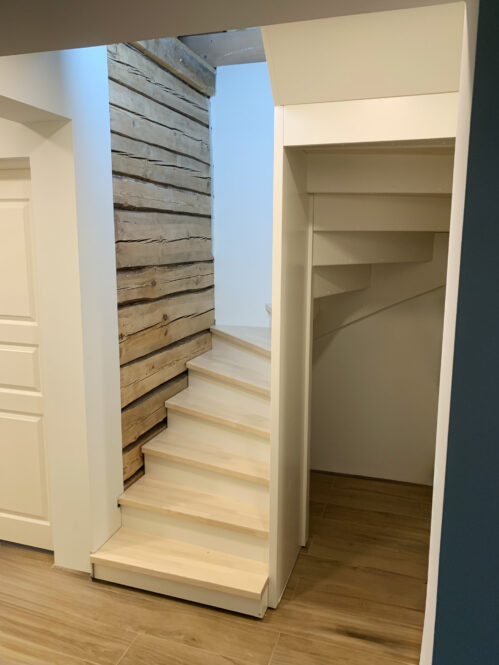 U-shaped staircase with ash wood steps and a light finish.