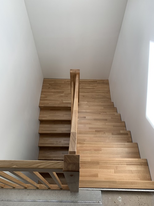 U-shaped staircase with oak steps featuring anti-slip grooves.