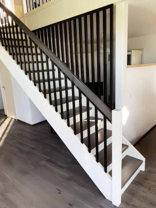 L-shaped staircase with dark finish and oak steps.