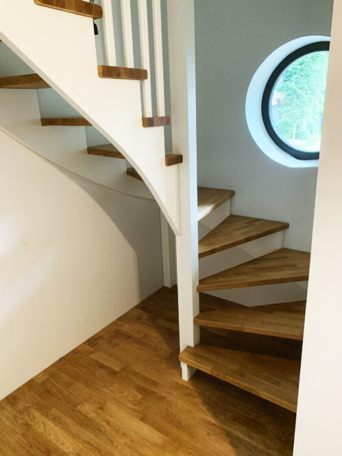 U-shaped staircase with modern stringers and oak steps.