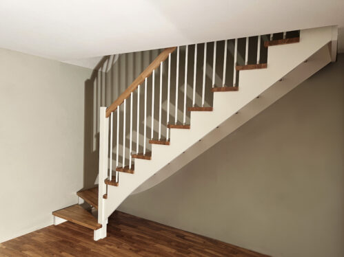 L-shaped staircase with modern stringers and light finish.