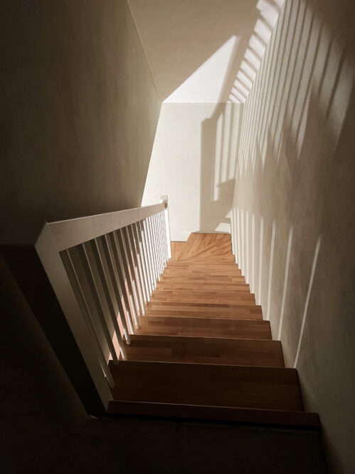 L-shaped staircase with oak steps and light finish.