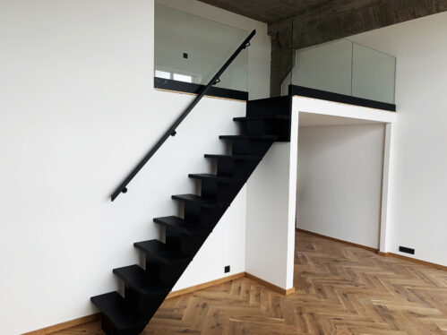 I-shaped designer staircase with central beam. Dark finish and oak steps.