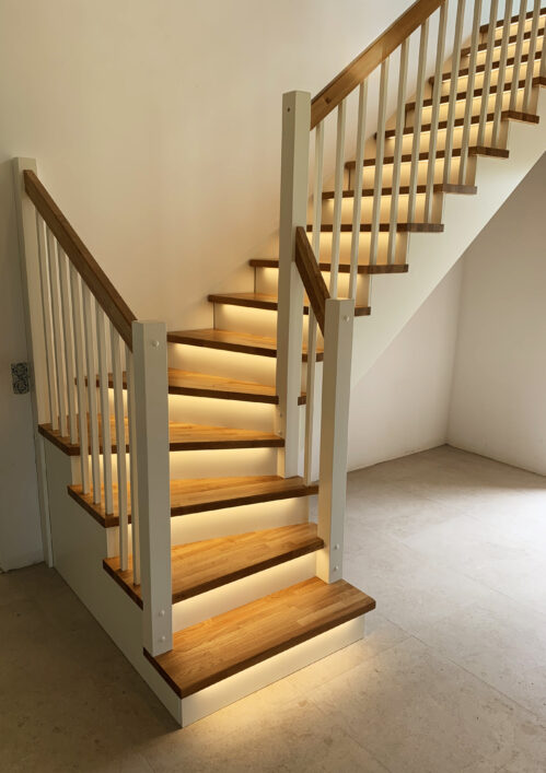 L-shaped staircase with LED lighting and modern stringers.