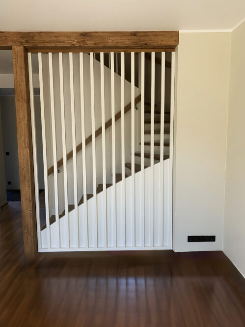 Wooden staircase with classic stringers, light finish, and pine steps.