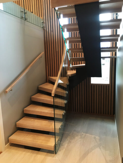 U-shaped staircase with oak steps and central beam. Material - wood-glass.