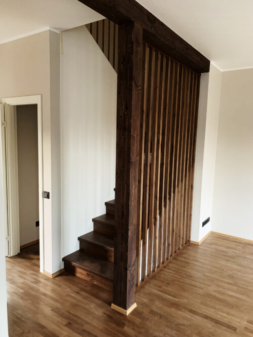 Wooden U-shaped staircase with pine steps and dark finish.