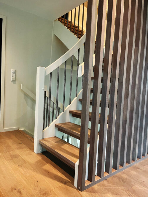 U-shaped wooden staircase with oak steps.