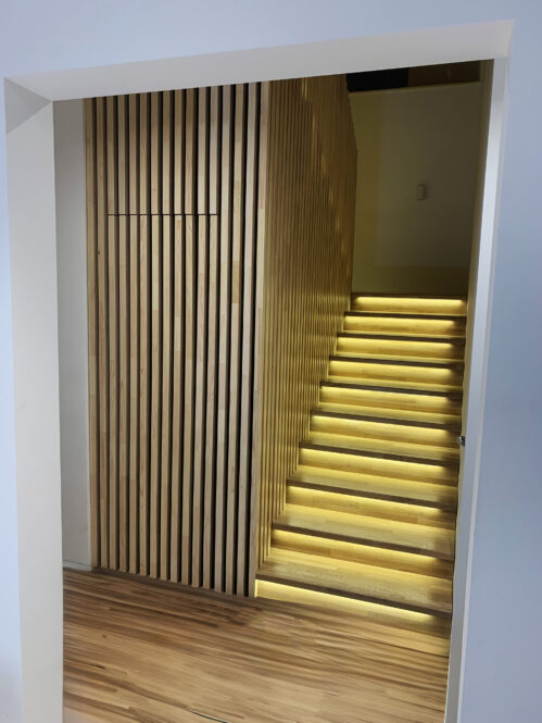 U-shaped staircase with oak steps and LED lighting.